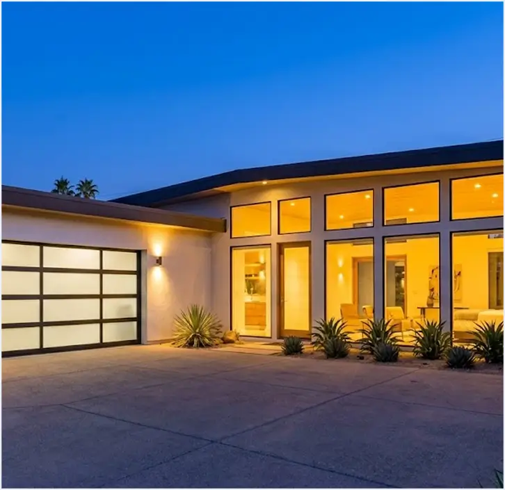 Modern desert home with a glass garage door and warm evening lighting