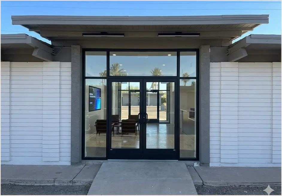 Desert home with black-framed glass garage doors